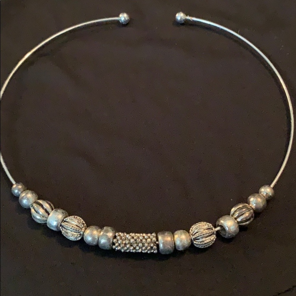 Silver tone slide necklace with beading. Flexes